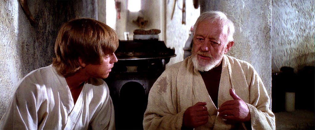 A young man (Luke Skywalker) and an older man (Obi Wan Kenobi) are sitting and having a discussion