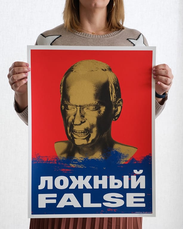 Woman holding up a protest poster. Poster is an image of an angry Putin, with the word FALSE below in Russian and English.